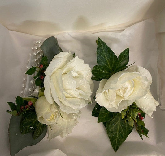 Two gorgeous wrist corsages made with white flowers and interesting green foliage to complement any outfit.